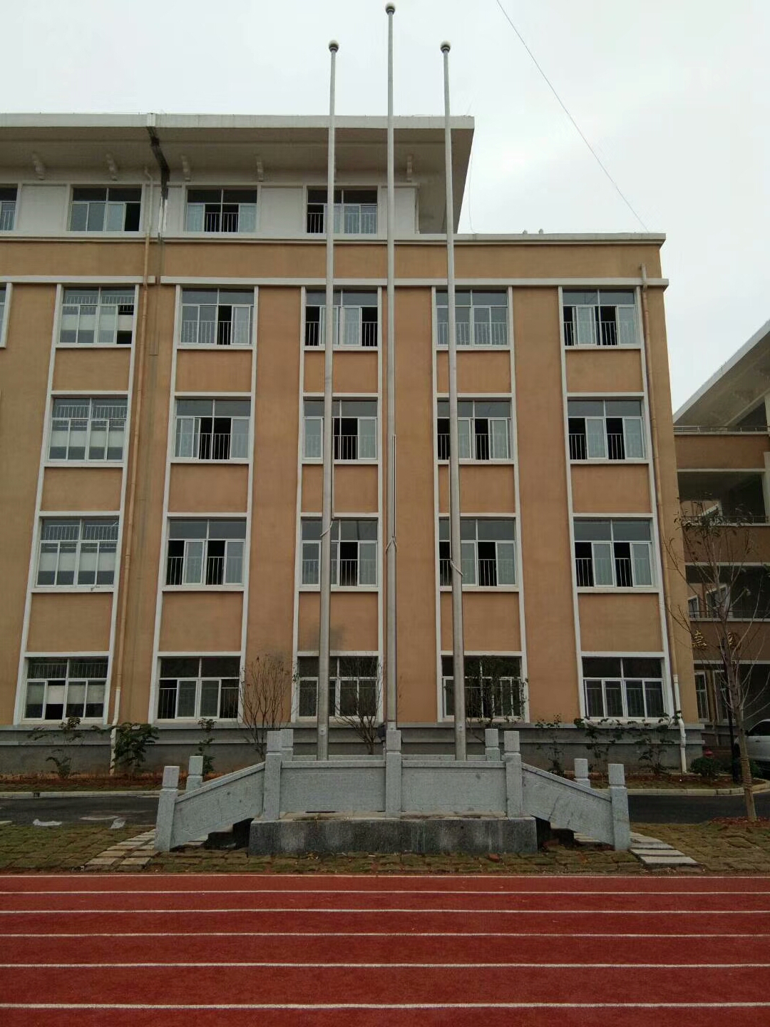 教学楼前三根旗杆灰色旗台安装效果